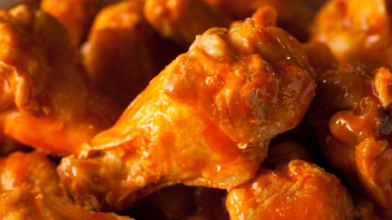 Close-up of Buffalo Wings coated in sauce, showing glossy texture after reheating